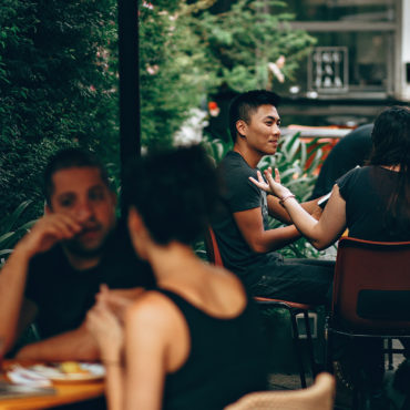 A busy outdoor setting with people working and eating in a green space