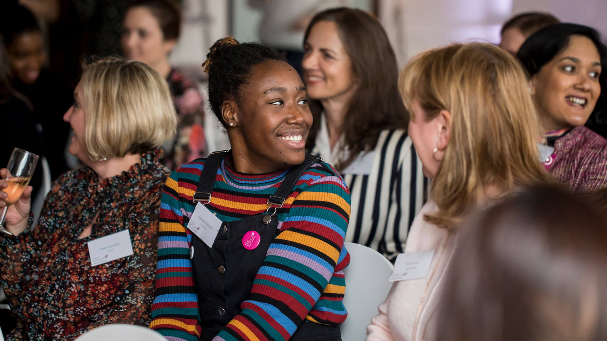 Group of women smiling and chatting at a charity networking event